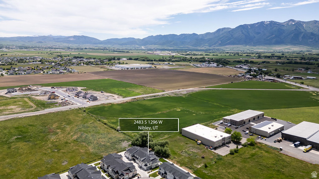 2483 South 1296th Street West Logan, UT 84321 - Photo 38 of 45 Aerial perspective showcasing residential development with mountain backdrops and surrounding green fields