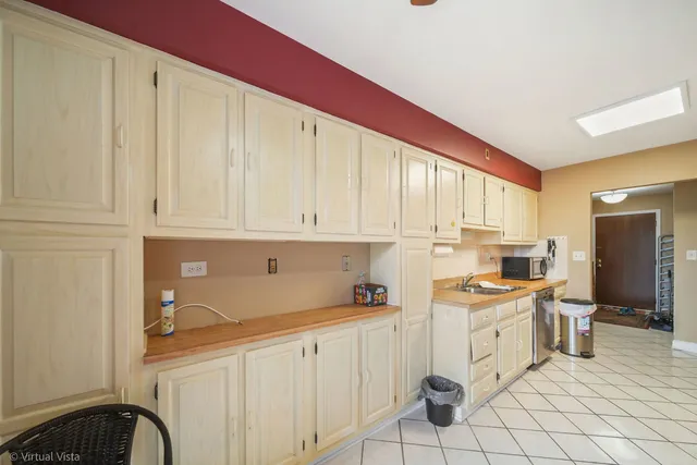 a kitchen with white cabinets and appliances