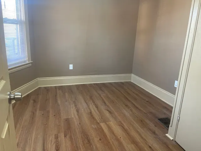a view of a room with wooden floor and small window