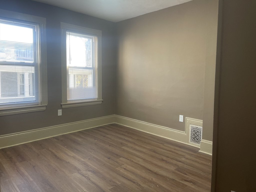 1002 River Street, Unit 2 Boston, MA 02136 - Photo 5 of 12 an empty room with wooden floor and windows