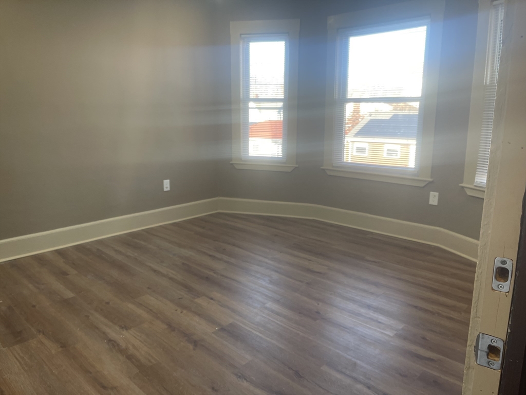 1002 River Street, Unit 2 Boston, MA 02136 - Photo 6 of 12 an empty room with wooden floor and windows