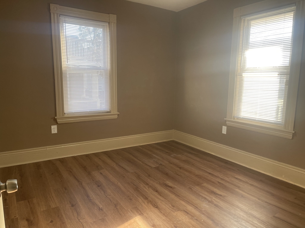 1002 River Street, Unit 2 Boston, MA 02136 - Photo 7 of 12 an empty room with wooden floor and windows
