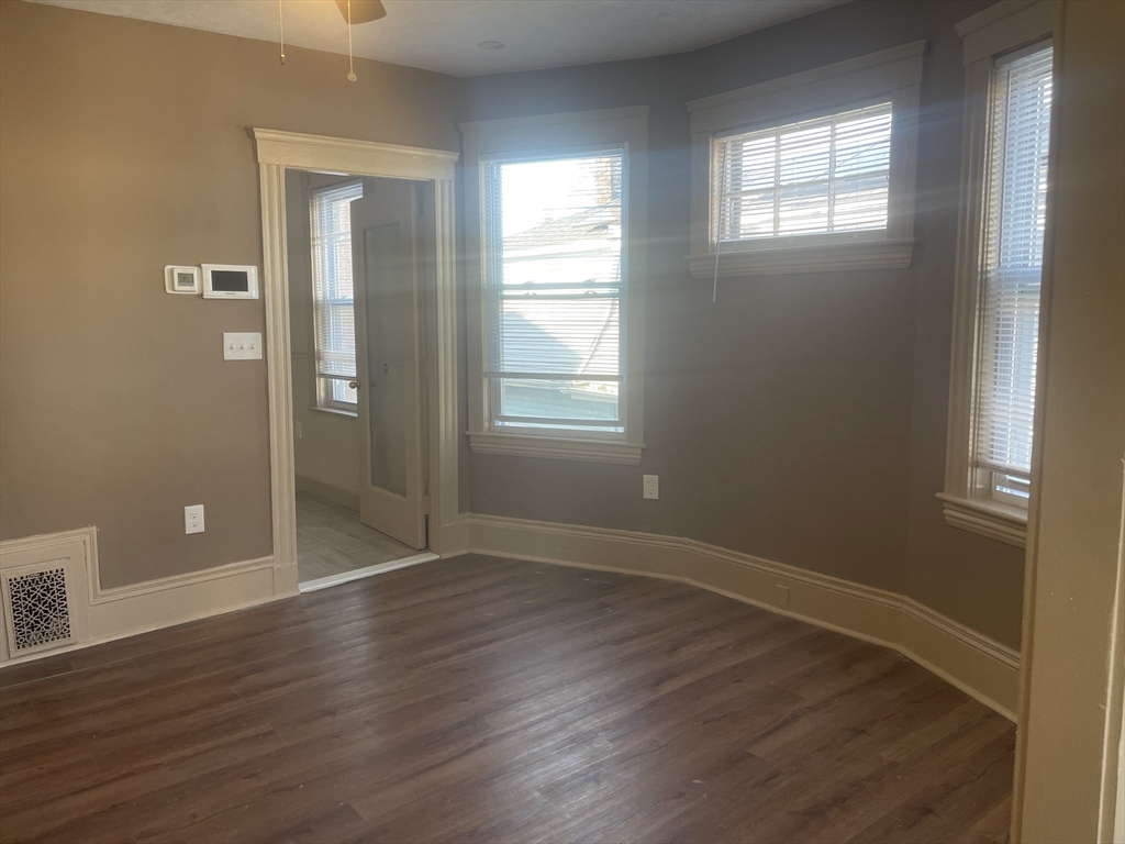 1002 River Street, Unit 2 Boston, MA 02136 - Photo 8 of 12 an empty room with wooden floor and windows