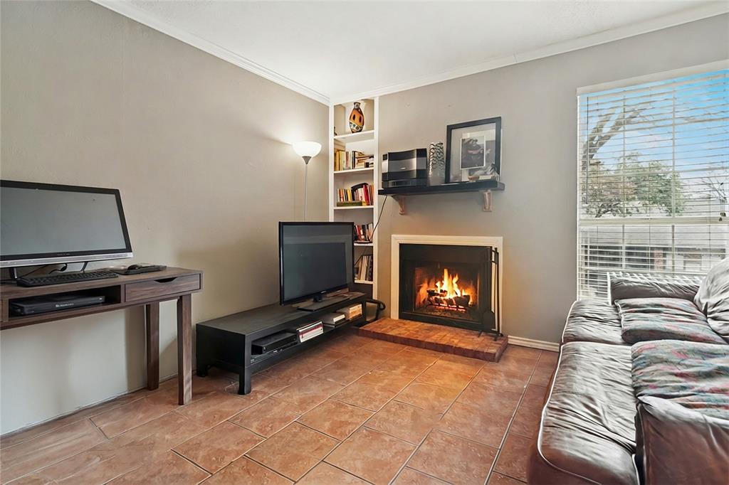 18333 Roehampton Drive, Unit 224 Dallas, TX 75252 - Photo 4 of 24 a living room with furniture a flat screen tv and a fireplace