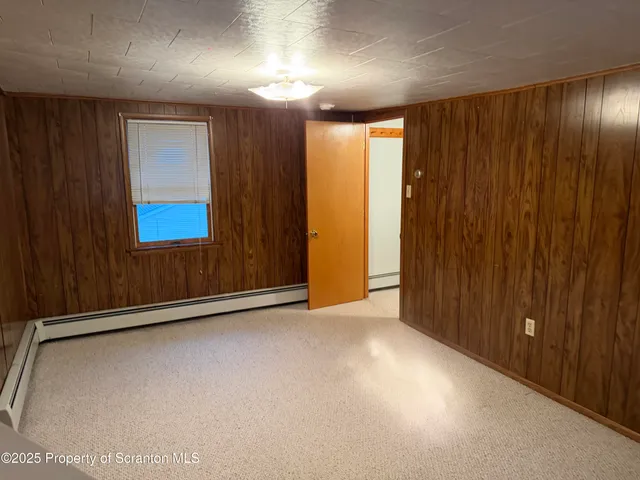 a view of an empty room with a cabinet and mirrors