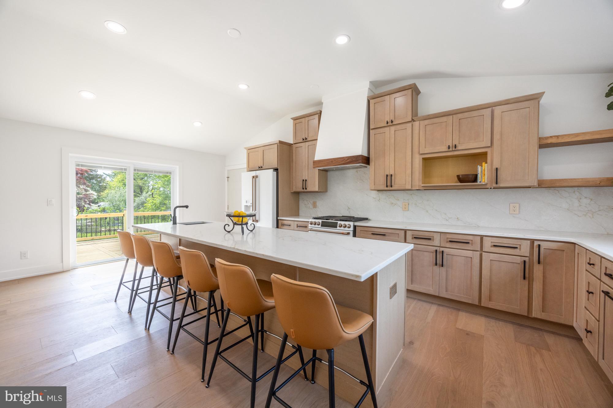 a kitchen with stainless steel appliances granite countertop a table chairs sink and cabinets