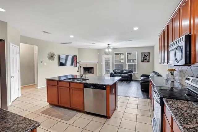 a kitchen with stainless steel appliances granite countertop a stove top oven a sink dishwasher and cabinets