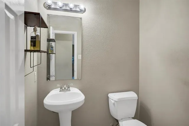 a bathroom with a toilet sink and mirror