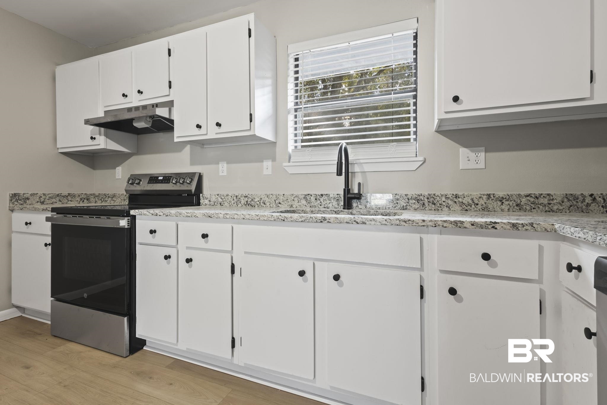 309 West Roosevelt Avenue Foley, AL 36535 - Photo 30 of 60 Kitchen featuring electric range, white cabinetry, light wood-type flooring, and sink