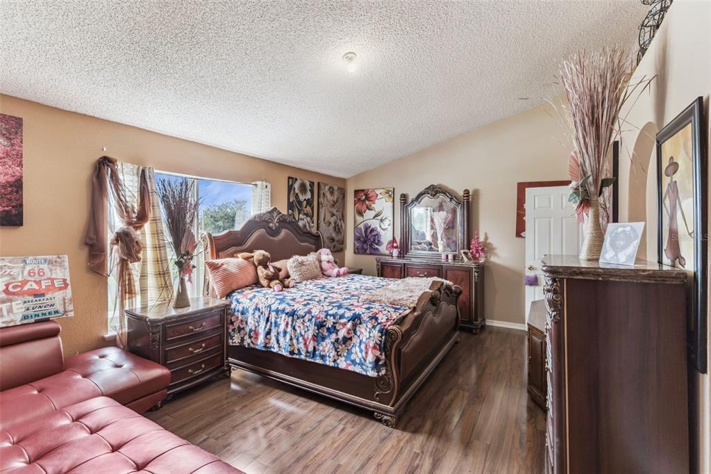 1849 Sunset Ridge Drive Mascotte, FL 34753 - Photo 16 of 29 a bedroom with a large bed and wooden floor