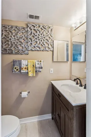a bathroom with a sink vanity and toilet