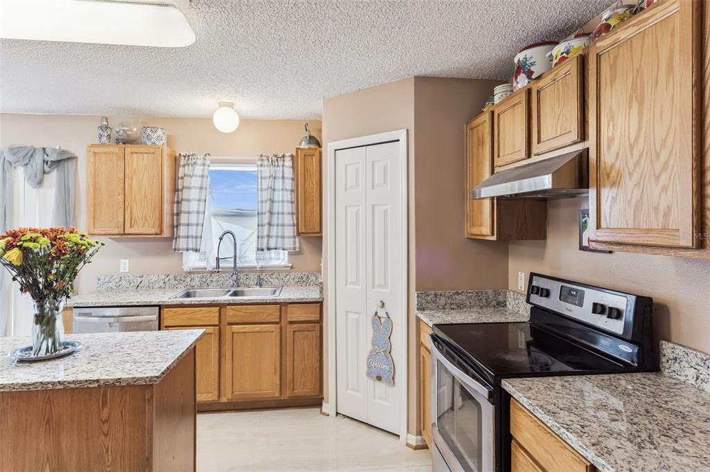 1849 Sunset Ridge Drive Mascotte, FL 34753 - Photo 5 of 29 a kitchen with stainless steel appliances granite countertop a sink stove and cabinets