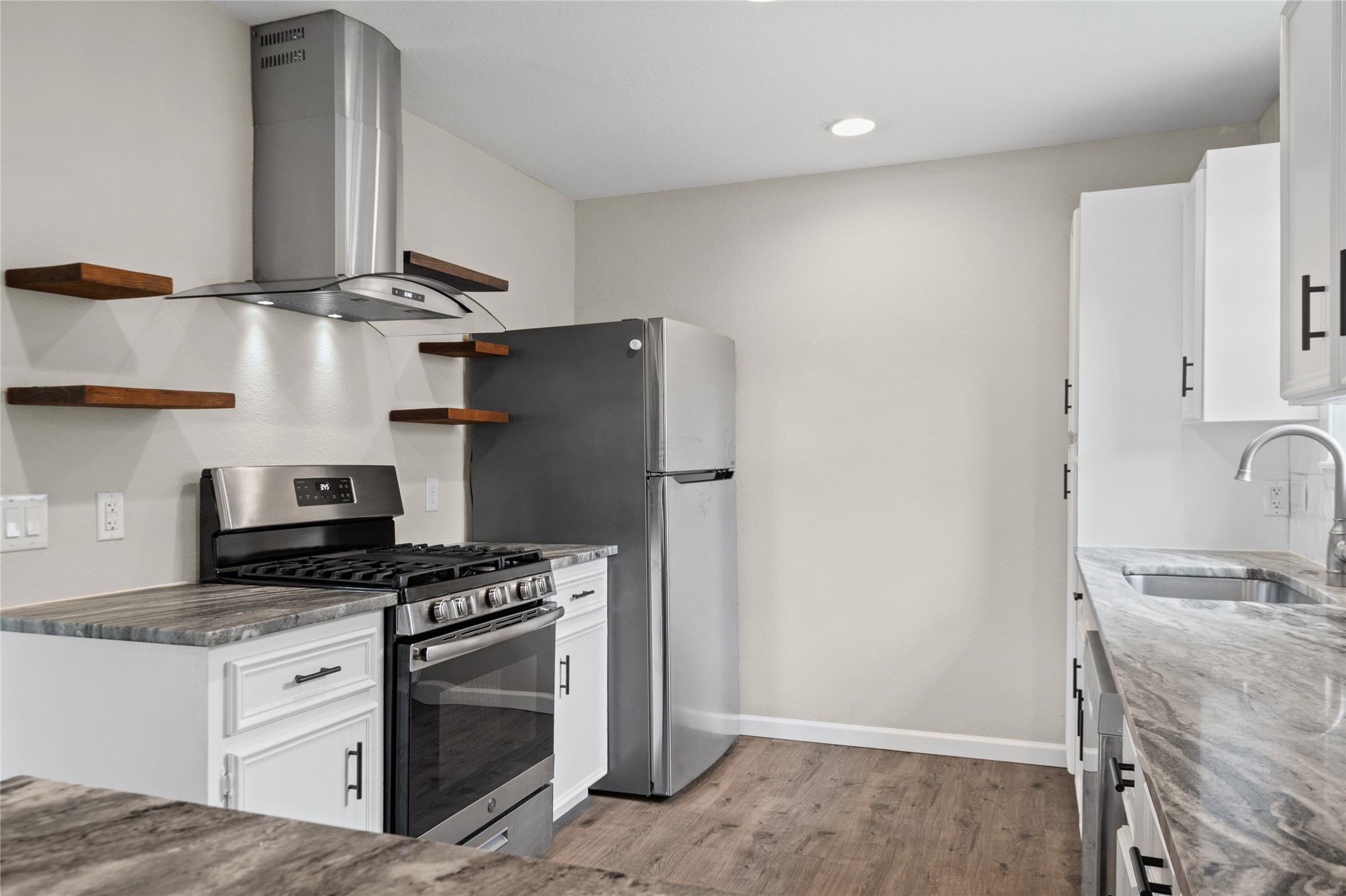 810 Stillhouse Spring Round Rock, TX 78681 - Photo 3 of 18 A well-equipped kitchen features a stainless steel range, matching refrigerator, and sleek gray countertops.