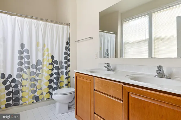 a bathroom with a granite countertop sink a toilet and a mirror