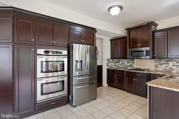 a kitchen with granite countertop a refrigerator stove and oven