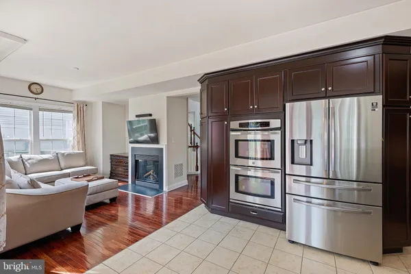 a kitchen with stainless steel appliances a refrigerator and wooden floor