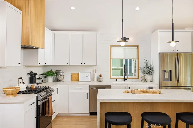 a kitchen with stainless steel appliances granite countertop a sink a stove and a refrigerator