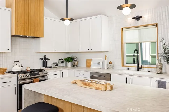 a kitchen with stainless steel appliances cabinets a stove a sink and a refrigerator