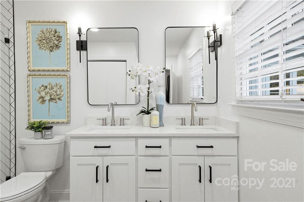 2326 Ferncliff Road Charlotte, NC 28211 - Photo 31 of 48 a bathroom with double vanity sinks a toilet a mirror and shower