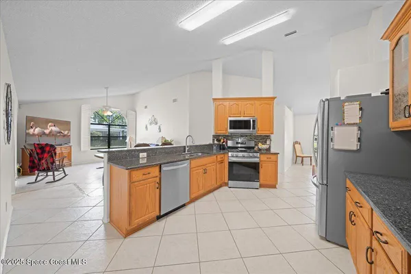 a large kitchen with stainless steel appliances granite countertop a stove and a sink