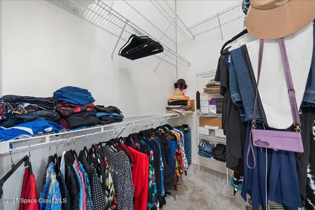 a view of walk in closet with clothes and shoes