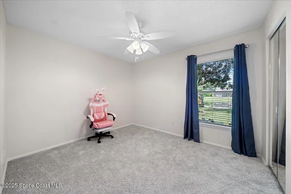 a room with a chandelier fan and a window
