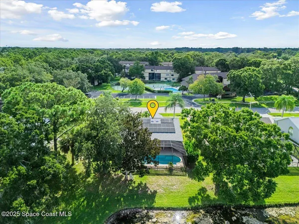 a view of a house with a swimming pool a yard and outdoor seating