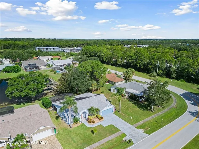 an aerial view of a house with garden space and street view