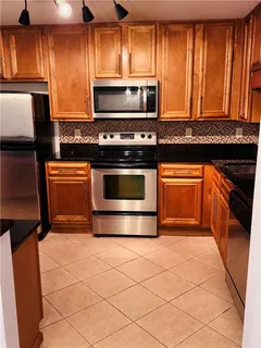 a kitchen with granite countertop a stove top oven microwave and cabinets