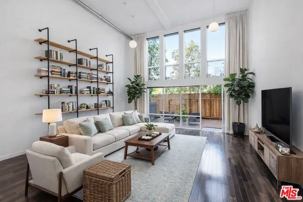 a living room with furniture a flat screen tv and a large window