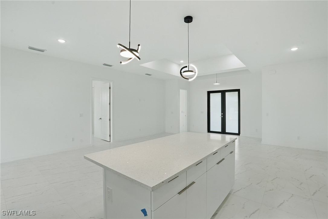 472 Rajah Street Lehigh Acres, FL 33974 - Photo 12 of 29 a kitchen with a refrigerator a sink and chandelier