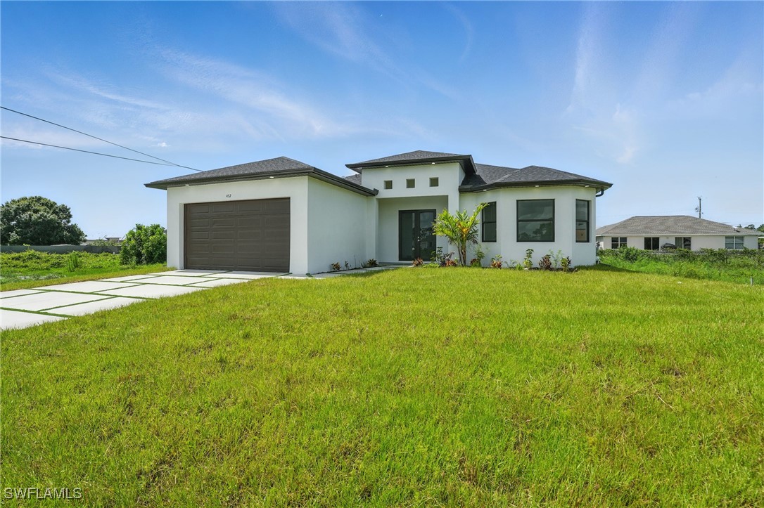 472 Rajah Street Lehigh Acres, FL 33974 - Photo 2 of 29 a front view of house with yard and green space