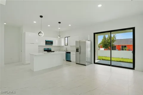 a kitchen with a sink a center island a stove cabinets and a window