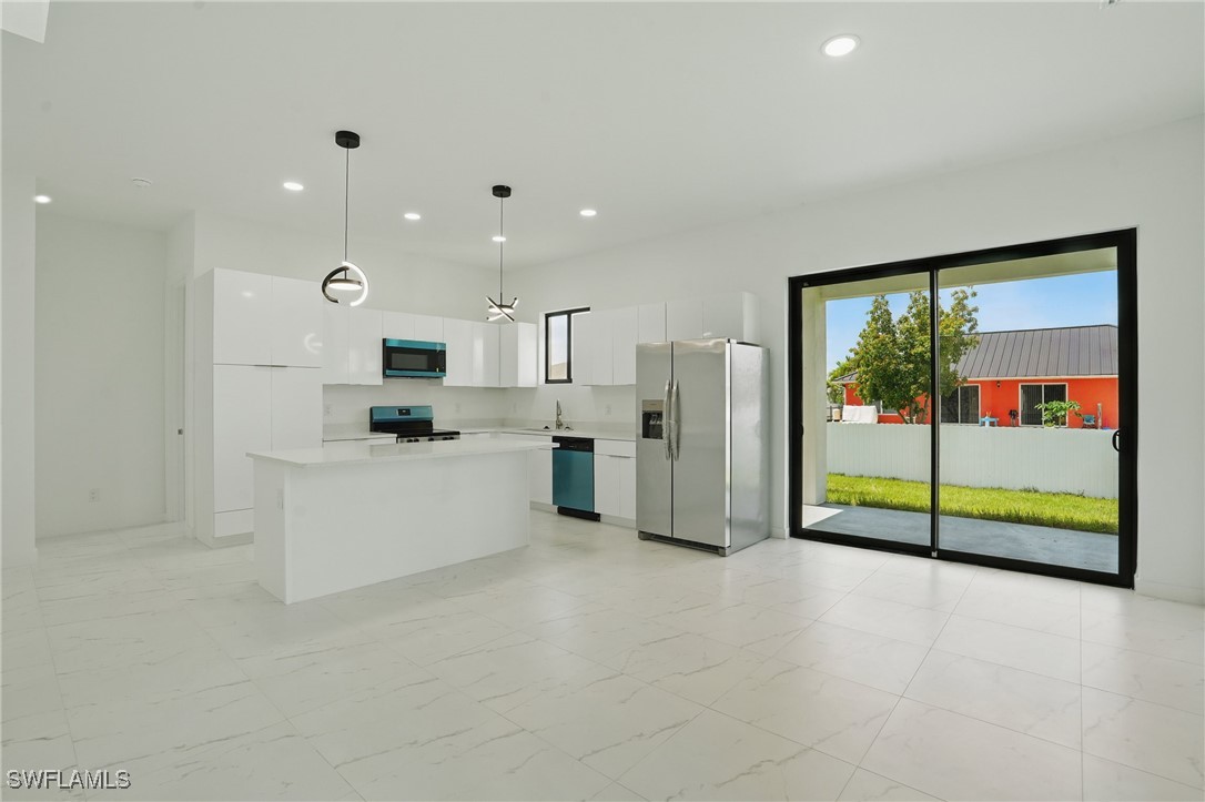 472 Rajah Street Lehigh Acres, FL 33974 - Photo 9 of 29 a kitchen with stainless steel appliances granite countertop a refrigerator and a sink