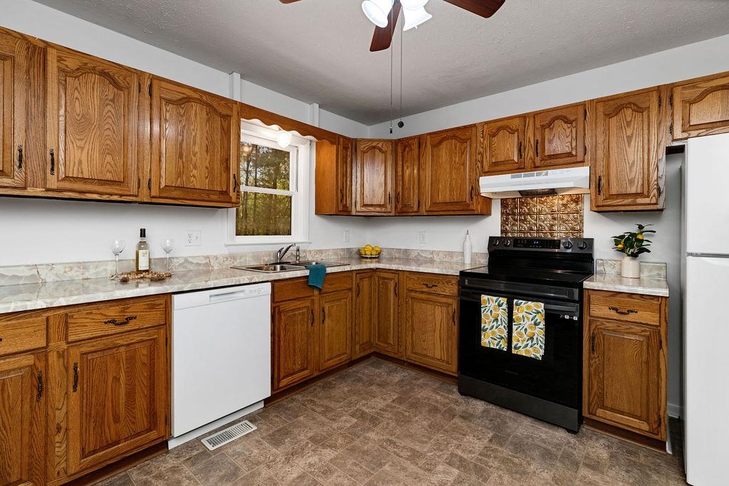 2051 Mt Torrey Road Lyndhurst, VA 22952 - Photo 32 of 67 a kitchen with granite countertop wooden cabinets a stove a sink and a window