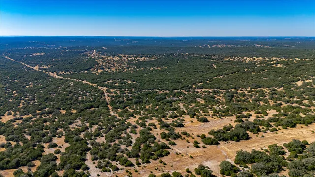an aerial view of residential houses with outdoor space and trees