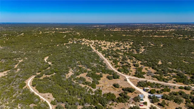 an aerial view of residential houses with outdoor space and ocean view