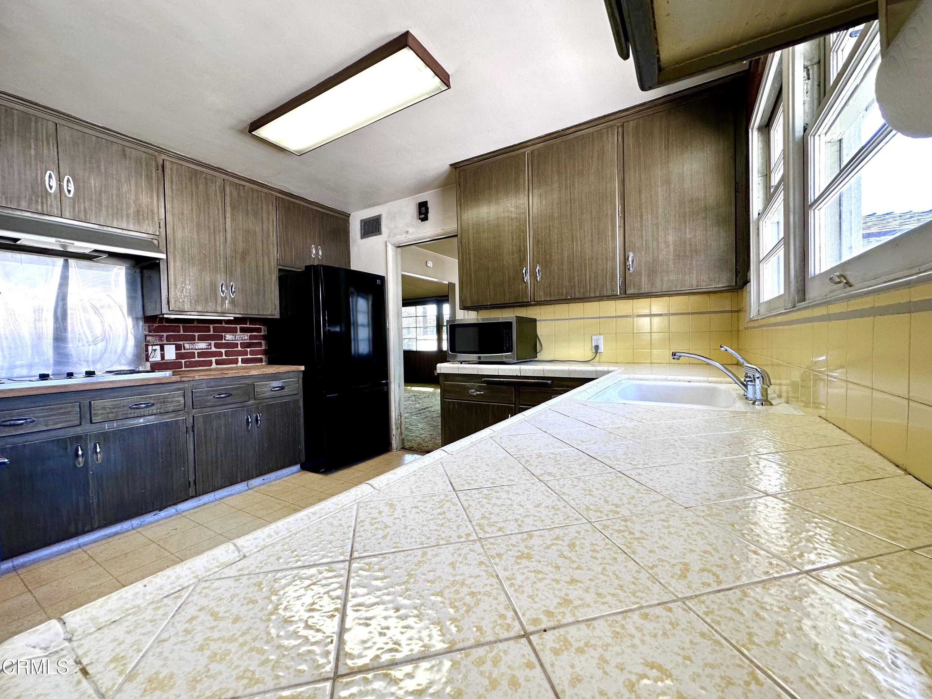 3895 Mayfair Drive Pasadena, CA 91107 - Photo 6 of 18 a kitchen with granite countertop a refrigerator and a stove top oven