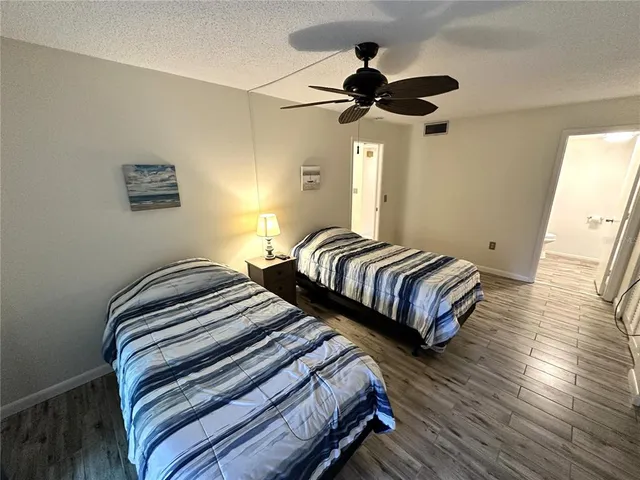 a bedroom with beds and a chandelier