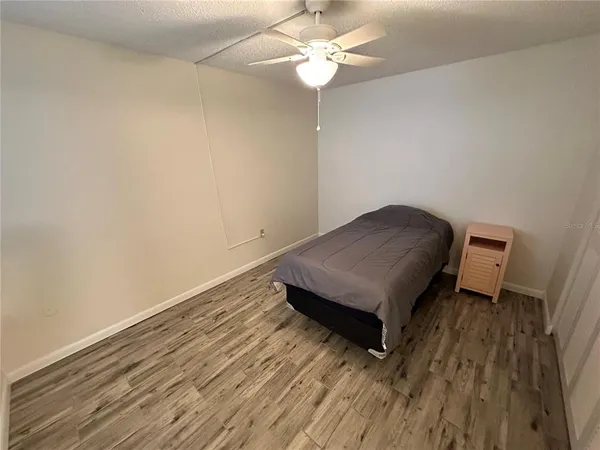 a living room with hard wood floors and a ceiling fan