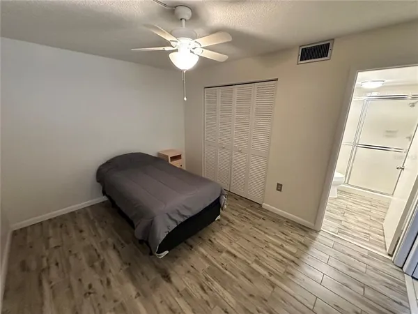 a living room with hard wood floor and a ceiling fan