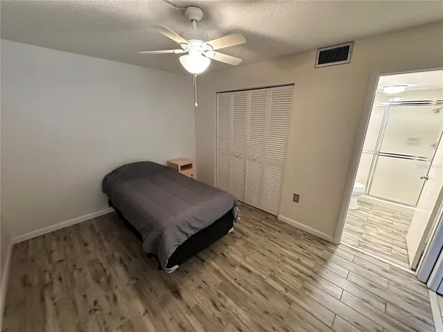 a living room with hard wood floor and a ceiling fan