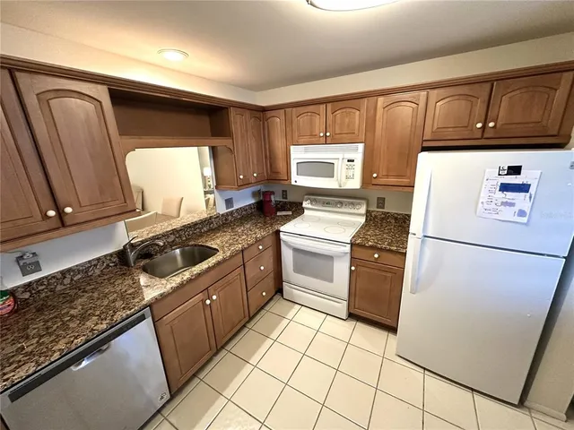 a kitchen with a stove a refrigerator and a sink
