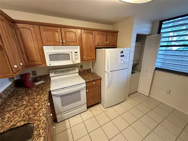 a kitchen with a refrigerator sink stove and cabinets