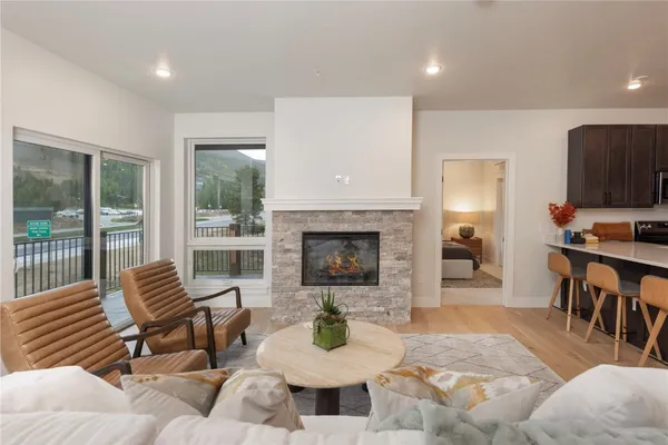 a living room with furniture kitchen view and a fireplace