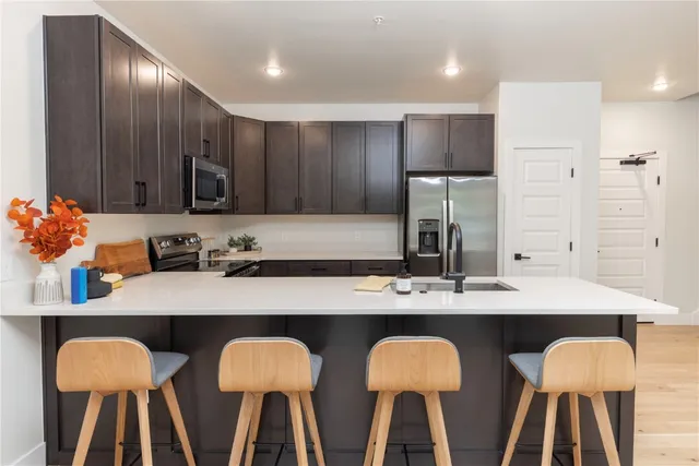a kitchen with stainless steel appliances a sink stove and refrigerator