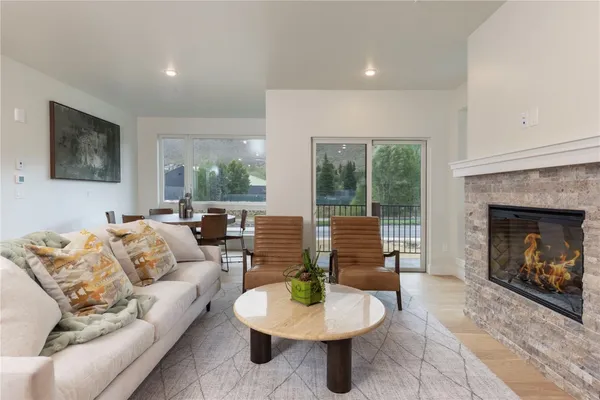 a living room with furniture a fireplace and a large window
