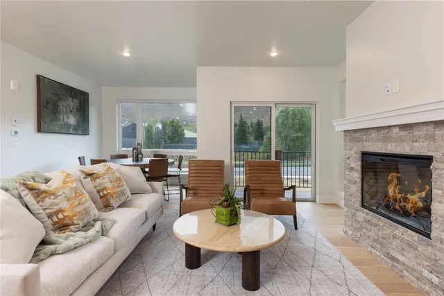 a living room with furniture a fireplace and a large window