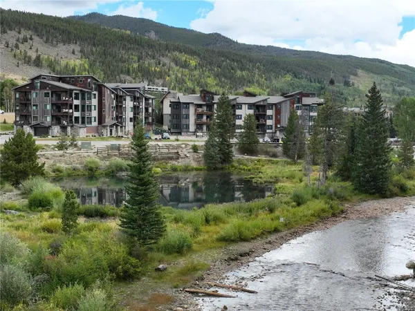 an aerial view of residential houses with outdoor space and lake view