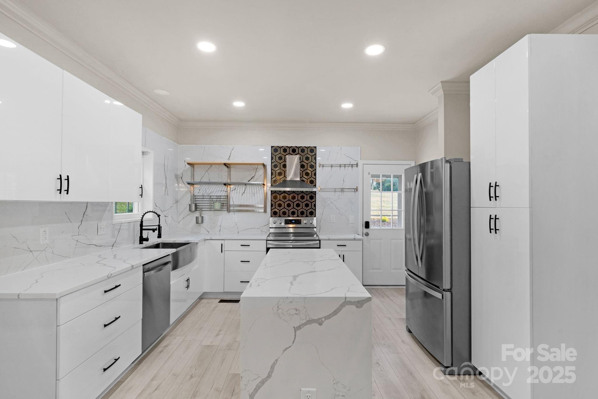 8891 Rock Hole Road Stanfield, NC 28163 - Photo 17 of 35 a kitchen with white cabinets and stainless steel appliances